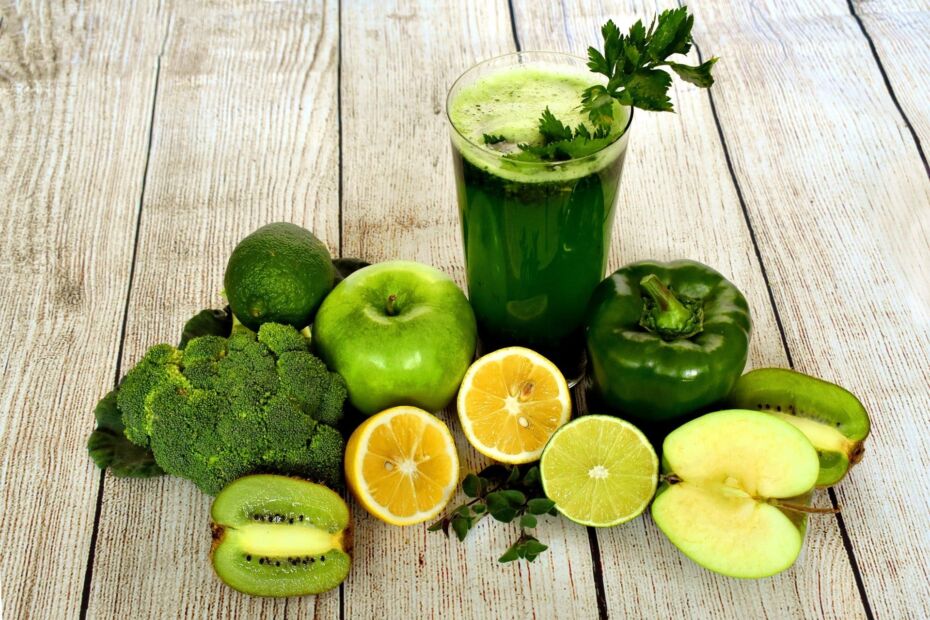 Un jus verts entouré de fruits et légumes qui sont un exemple de santé du corps et même de l'esprit.