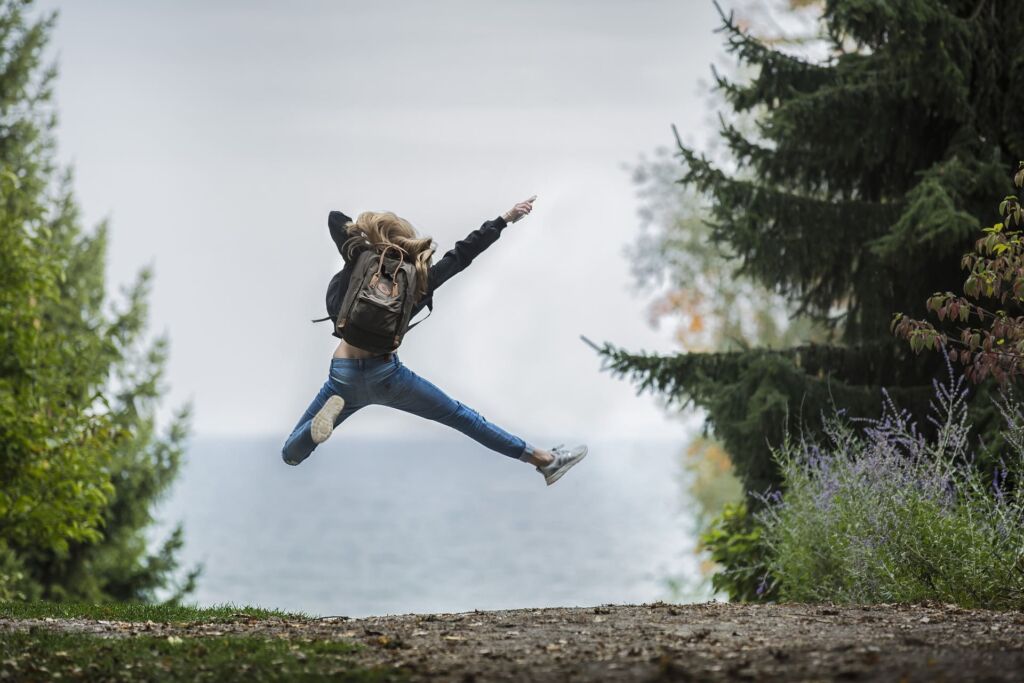 jeune femme sautant en l'air dans la nature, preuve d'une conscience joyeuse