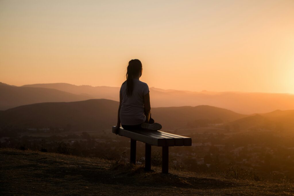 femme en méditation devant un couché de soleil dans une consultation individuelle